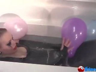 Lateks dressed young lady with balloons in a bathtub